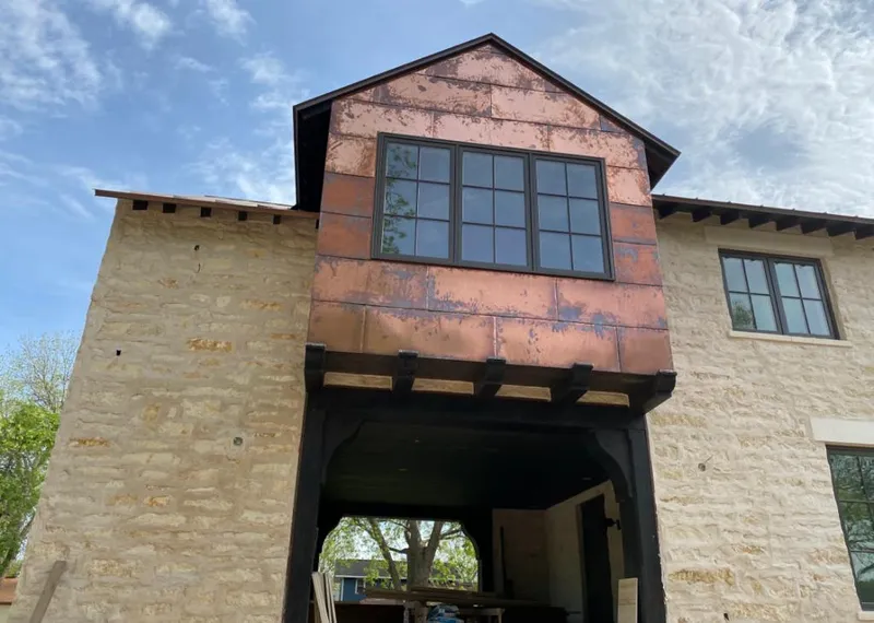 Copper metal panel facade on a stone building for Roof Repair in Fayetteville